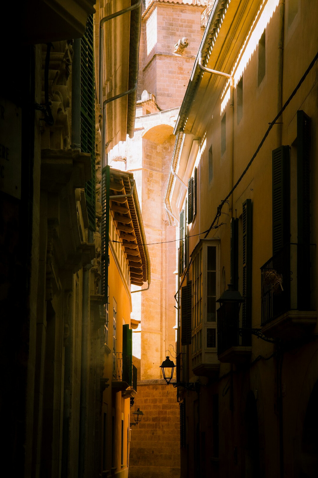 Narrow old city street at dusk with warm lights